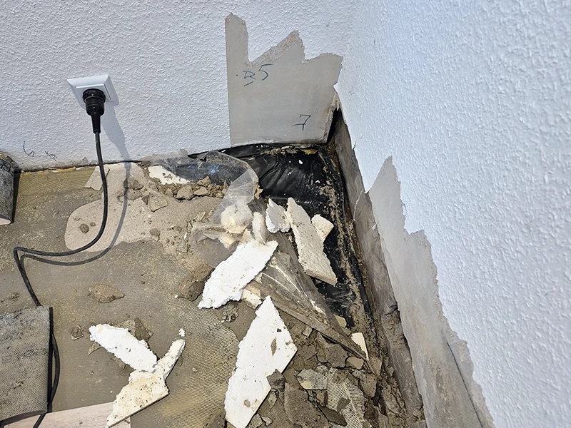 Geöffneter Bodenaufbau mit freigelegtem Estrich zur Feuchtigkeitsprüfung