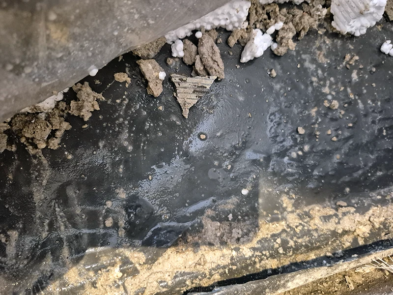 Feuchter Estrich im geöffneten Bodenbereich nach Wasserschaden